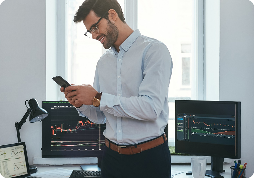 Trader observando gr?ficos en varios monitores